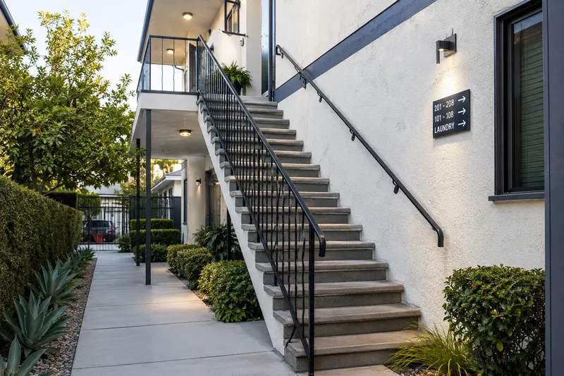 Well-lit exterior staircase with a handrail on a rental property, illustrating landlord liability coverage for tenant and guest injuries