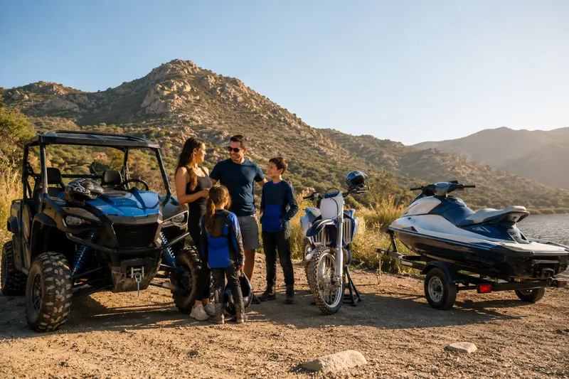 Family with ATV, dirt bike, jet ski, and trailer on an off-road trail, showing recreational insurance coverage from Online General Insurance in Tarzana, CA